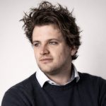 Man met krullend haar en trui